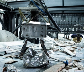 Advanced recycling in construction waste management. Robotic arm sorting metal and debris at a recycling facility.