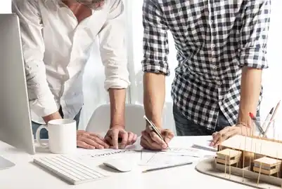 Tailored Cleantech for Smarter Projects. Two professionals analyzing plans at a desk representing smart cleantech matchmaking.