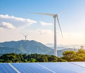 Clean Energy Solutions for Efficient Building Management. Wind turbines and solar panels in a green landscape representing clean energy solutions.