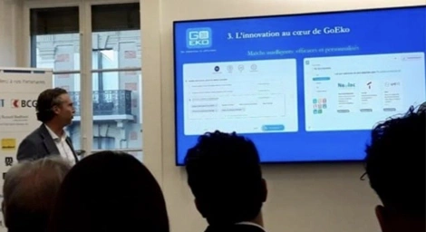 Raphaël Herrera Presenting GoEko and Its Innovative Platform. Raphaël Herrera presenting the GoEko platform at an event, standing next to a screen displaying a product demo.