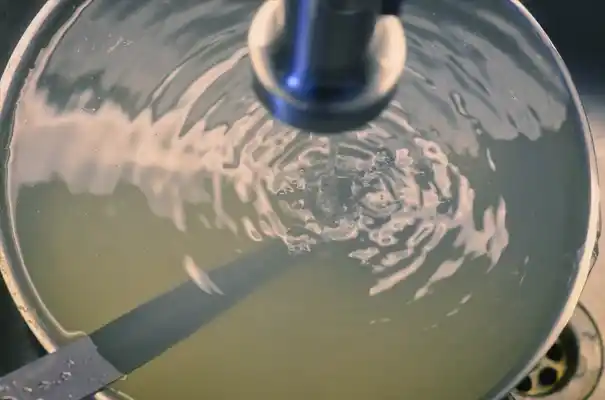 Smart Water Management for Maximum Efficiency. Stream of water filling a pot in a sink representing consumption monitoring and control.