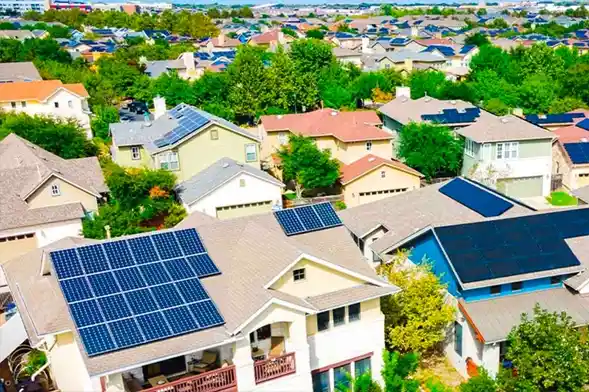 Empowering Communities Through Sustainable Energy. Aerial view of a residential neighborhood with solar panels installed on rooftops.