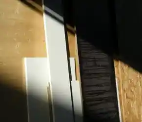 Build Responsibly with Sustainable Materials. Sunlight casting shadows over stacked eco-friendly construction panels.