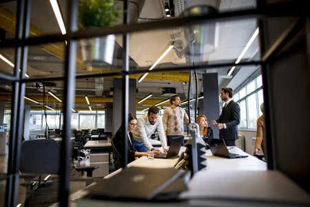 Enabling Sustainable Finance Through Smart Collaboration. Team of professionals collaborating in a modern office focused on sustainable project financing.