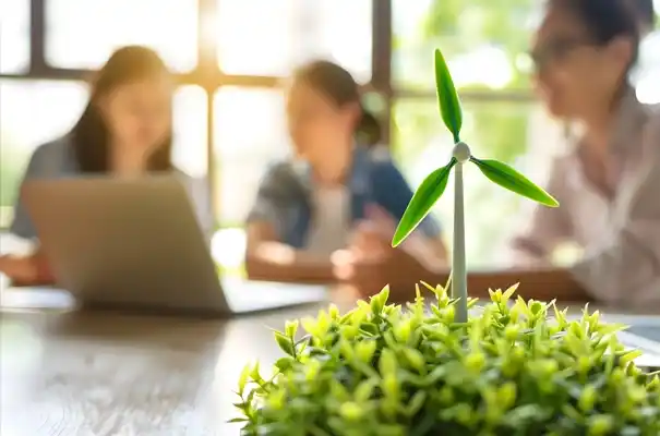 Powering Green Finance Through Smart Collaboration. Mini wind turbine on a green plant with business professionals collaborating in the background.