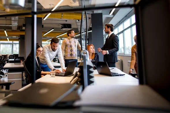 Collaborative Teamwork for Sustainable Business Solutions. Team collaborating in a modern office focused on sustainable business practices.