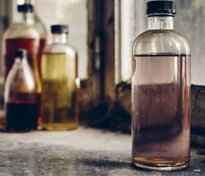 Safe Handling and Management of Toxic Materials. Bottles containing hazardous liquids representing toxic material storage and control.