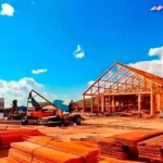 Construction site showing wood-frame building and reused materials for circular economy.
