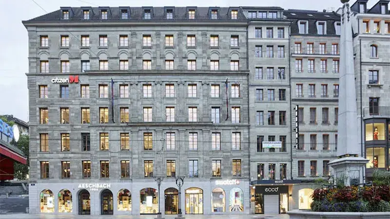 Facade of the CitizenM Hotel in Geneva with shops on the ground floor.